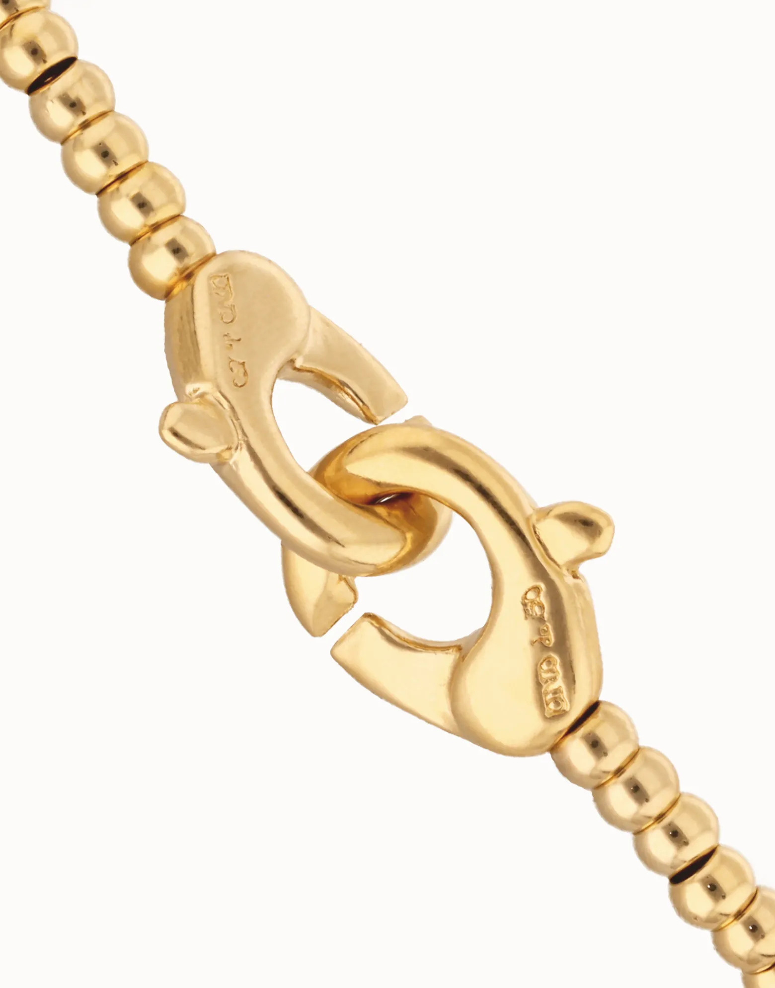 Pulsera de bolas pequeñas bañada en oro con mosquetón entrelazado