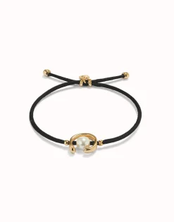 Pulsera de hilo negro con perla shell fornitura bañada en oro 18k.