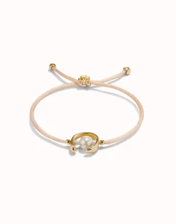 Pulsera de hilo salmón con perla shell fornitura bañada en oro 18k.